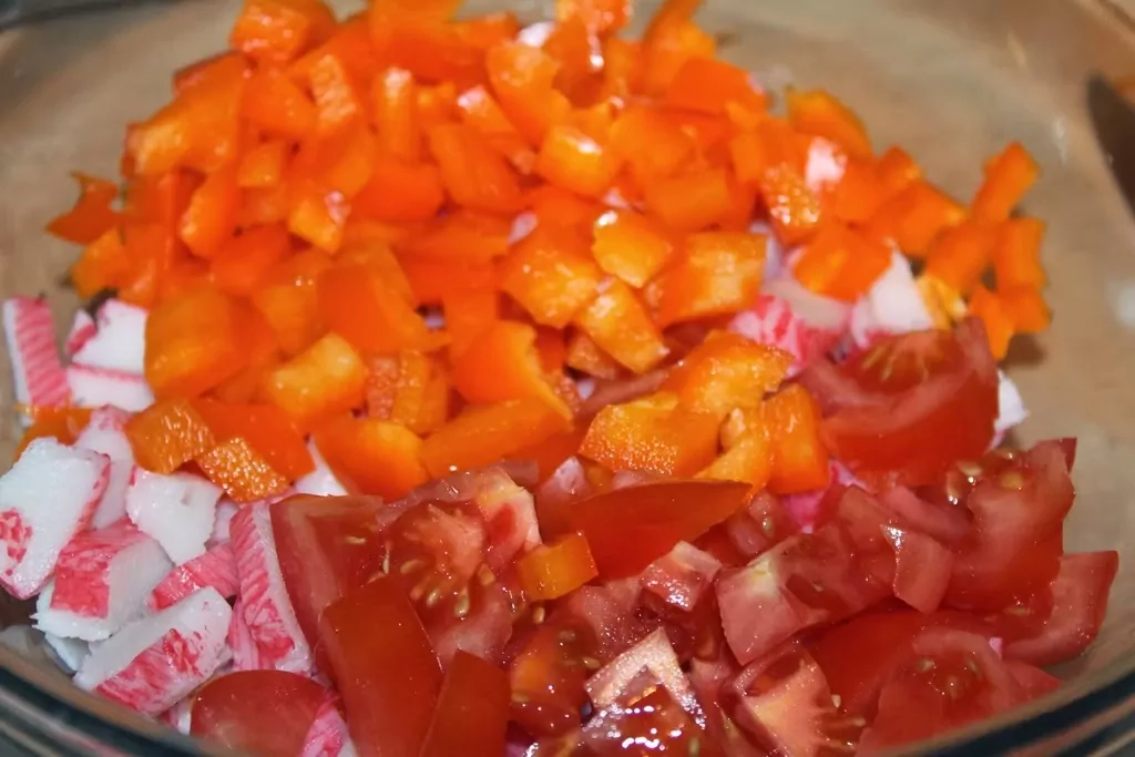 Krabju nūjiņu salāti ar rīsiem, konservētu kukurūzu, tomātiem un papriku