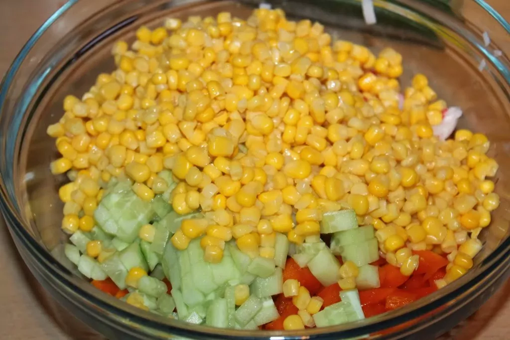 Krabju nūjiņu salāti ar rīsiem, konservētu kukurūzu, tomātiem un papriku