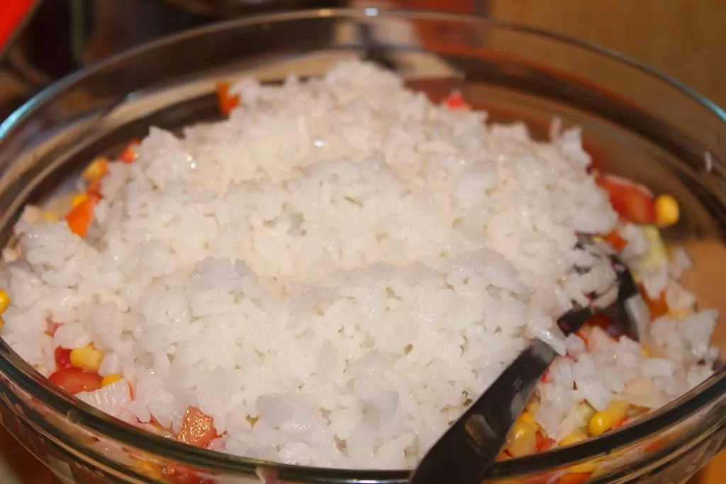 Krabju nūjiņu salāti ar rīsiem, konservētu kukurūzu, tomātiem un papriku