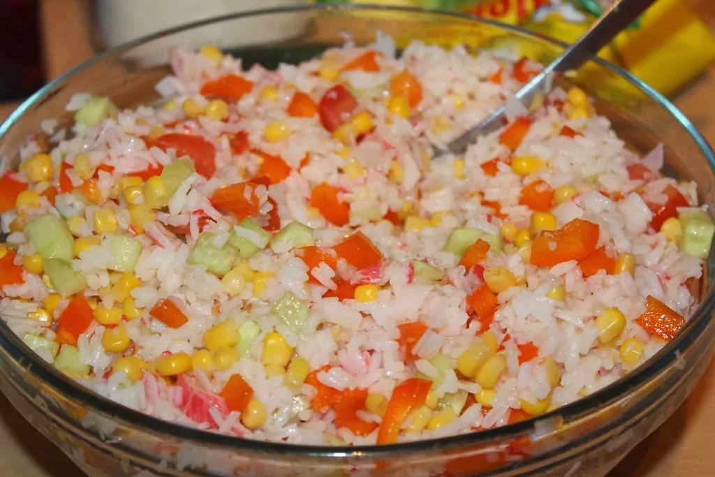 Krabju nūjiņu salāti ar rīsiem, konservētu kukurūzu, tomātiem un papriku