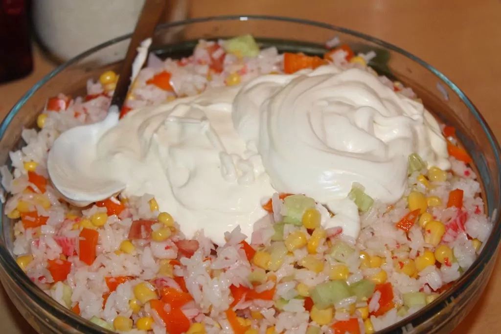 Krabju nūjiņu salāti ar rīsiem, konservētu kukurūzu, tomātiem un papriku