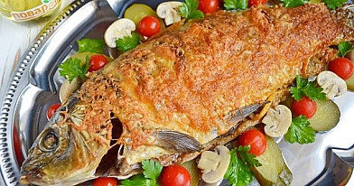 Delicious oven-roasted carp in a sleeve with carrots and onions