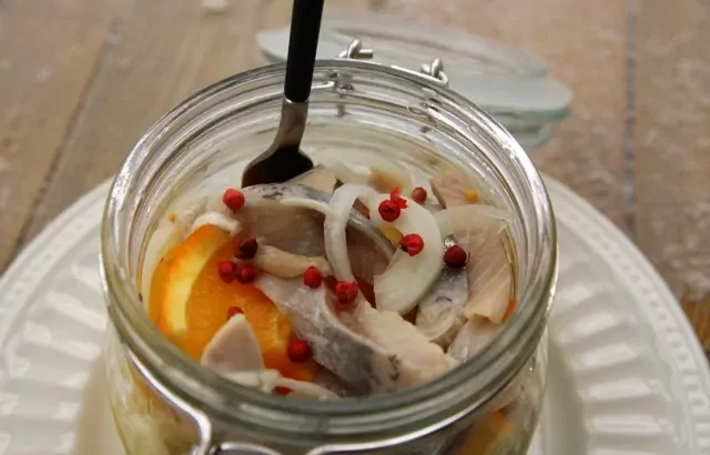 Orangenhering mit rosa Pfefferkörnern und weißen Zwiebeln