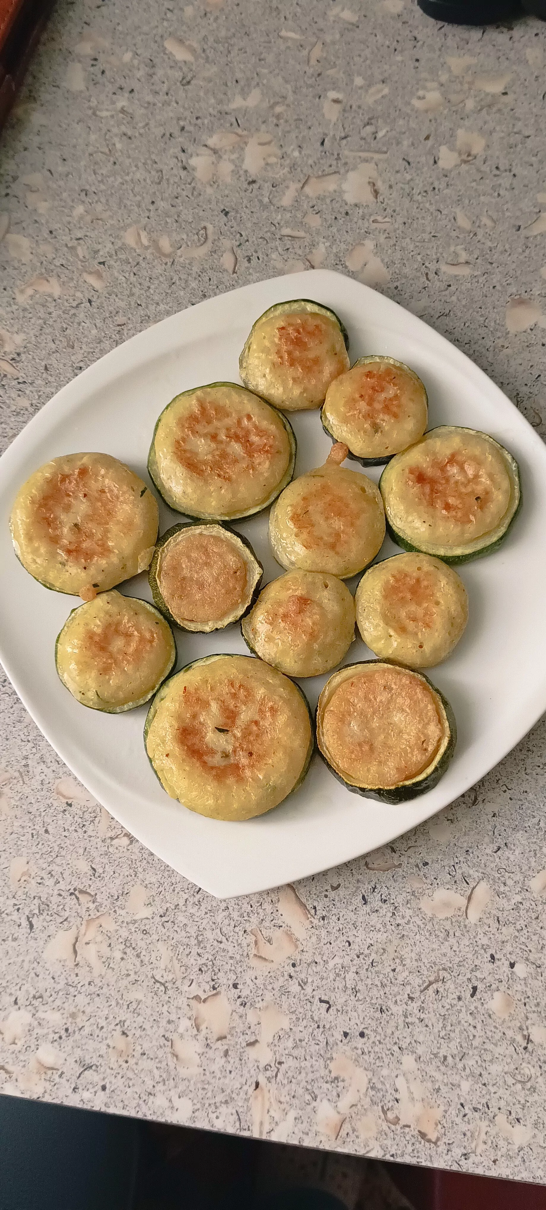 Kepta tarkuota cukinija cukinijų žieduose, tarsi blyneliai