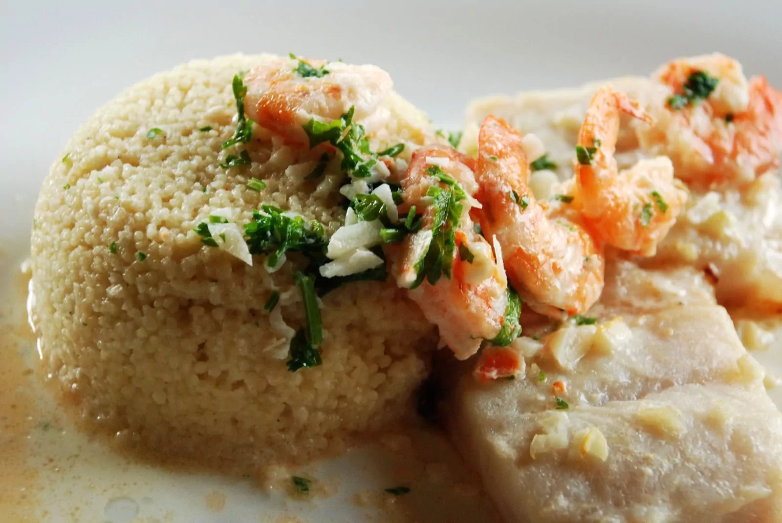 Oven-baked fish with prawn-cream sauce and couscous
