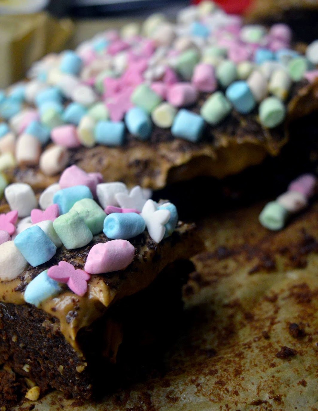 supjaustytas šokoladinis pyragas su riešutais, riešutų sviesto kremu ir zefyriukais 