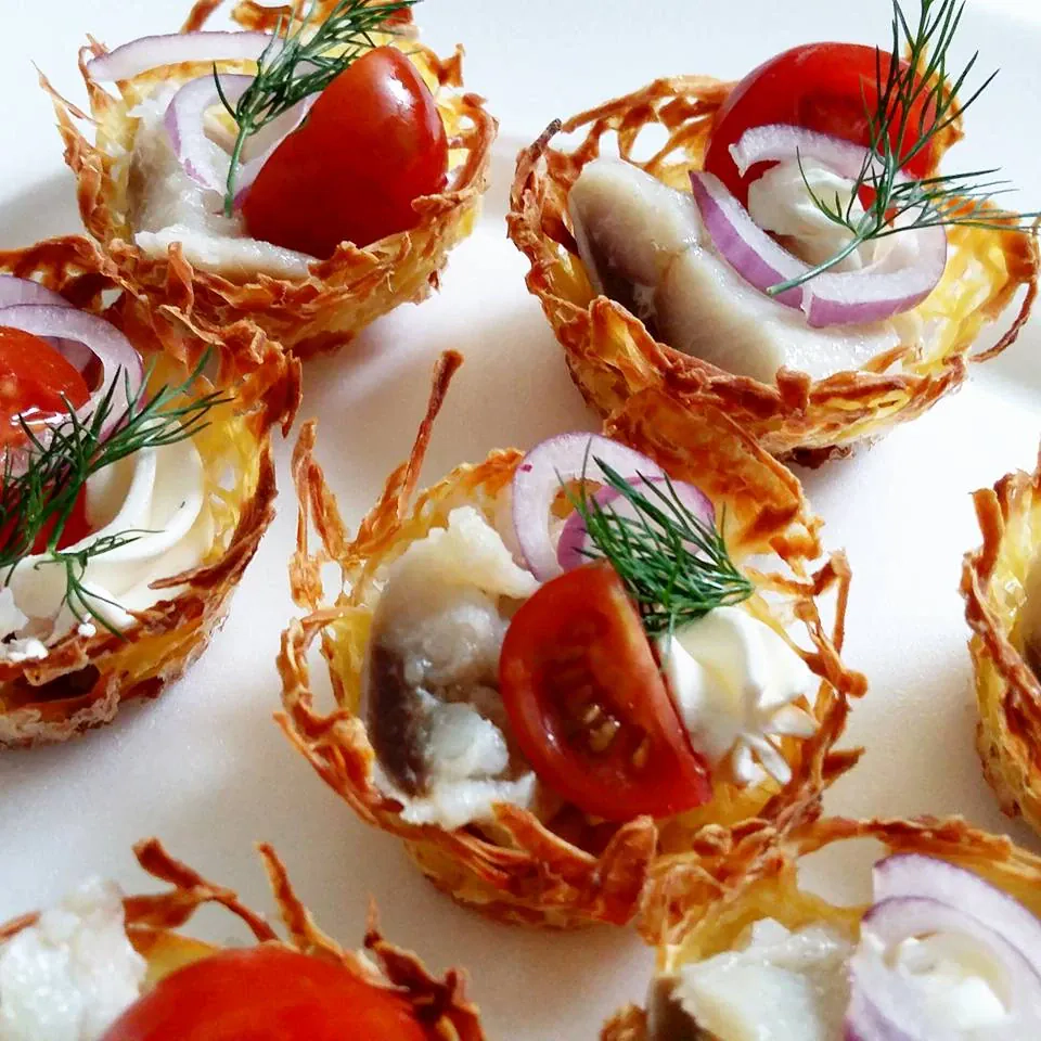 Vieno kąsnio bulvių lizdeliai su silke, svogūnais ir vyšniniais pomidorais