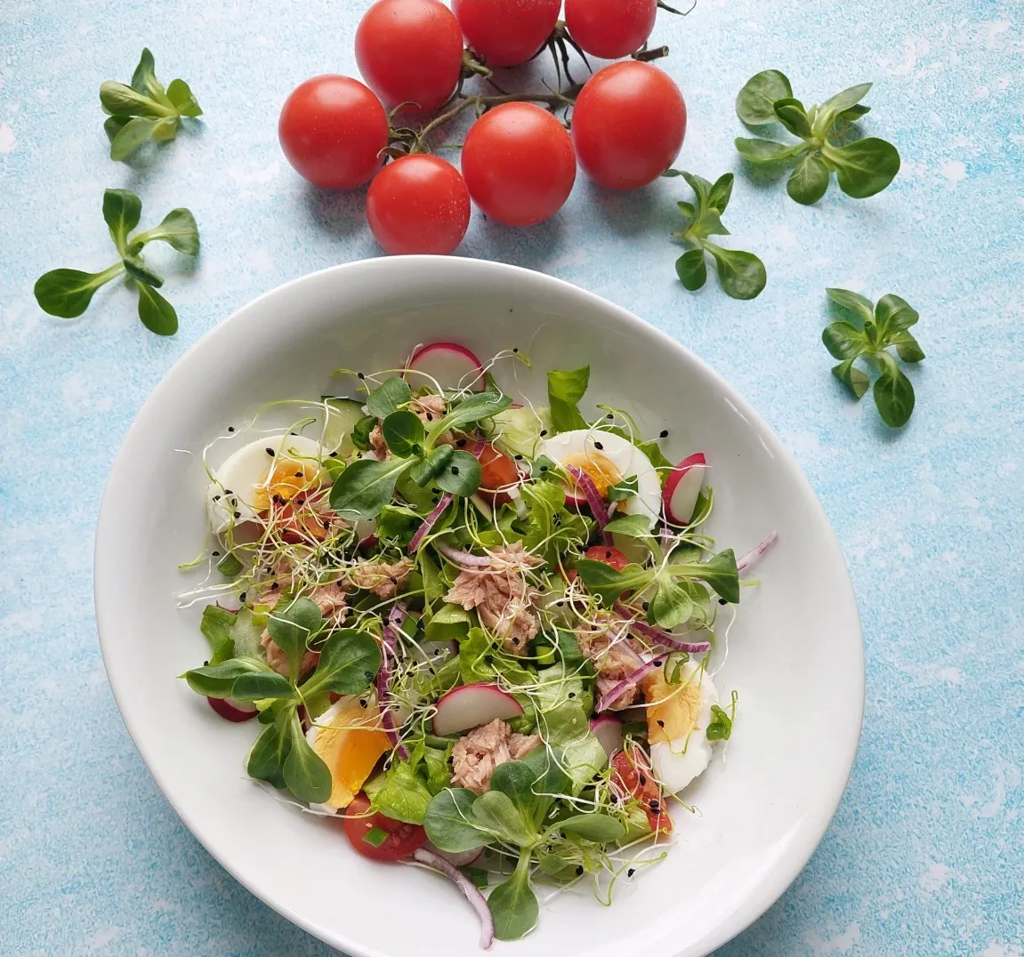 Salotos su tunu, agurkais, vyšniniais pomidorais, kiaušiniais ir ridikėliais