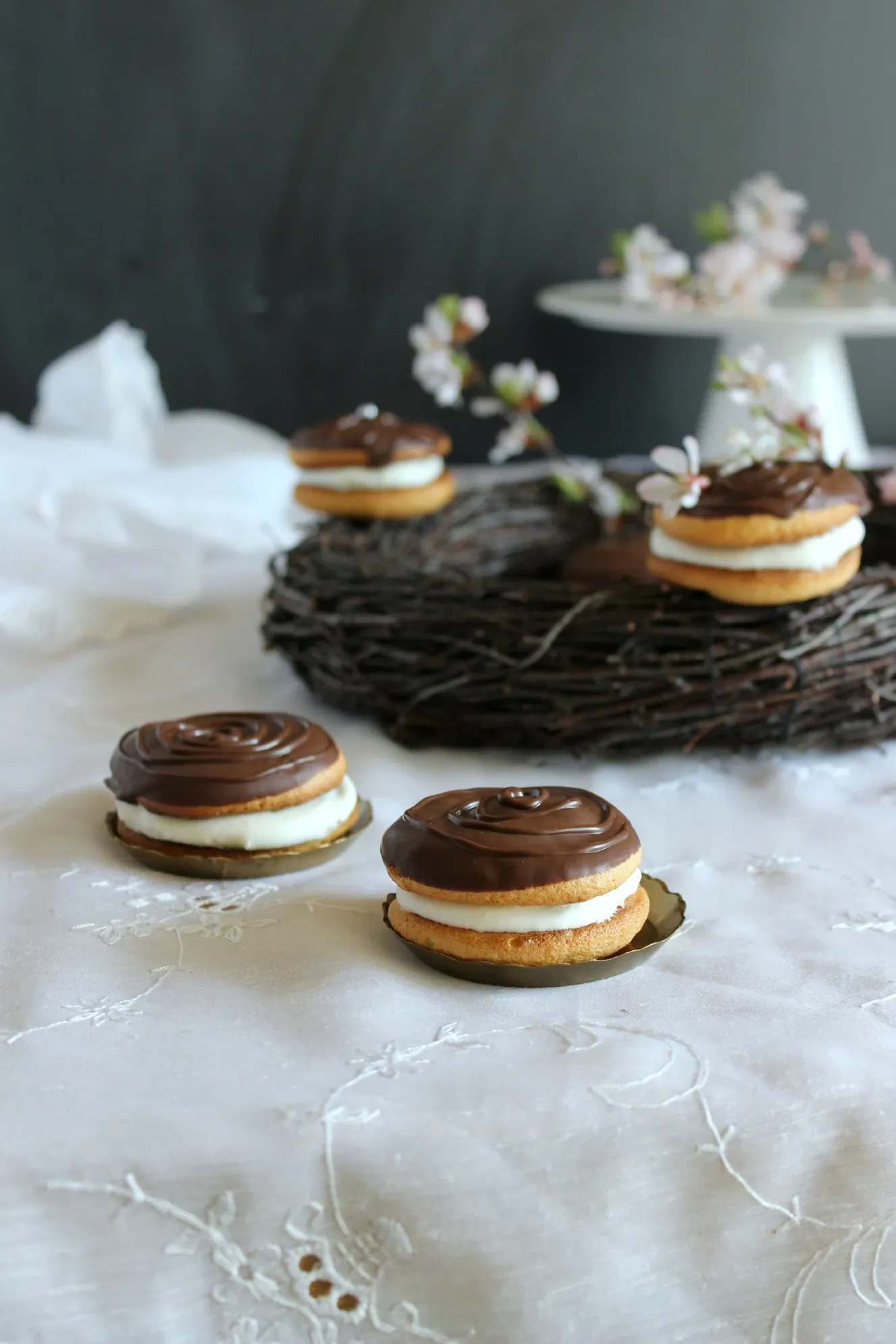 Biskvitiniai glaistyti pyragaičiai su grietinėle ir šokoladine glazūra