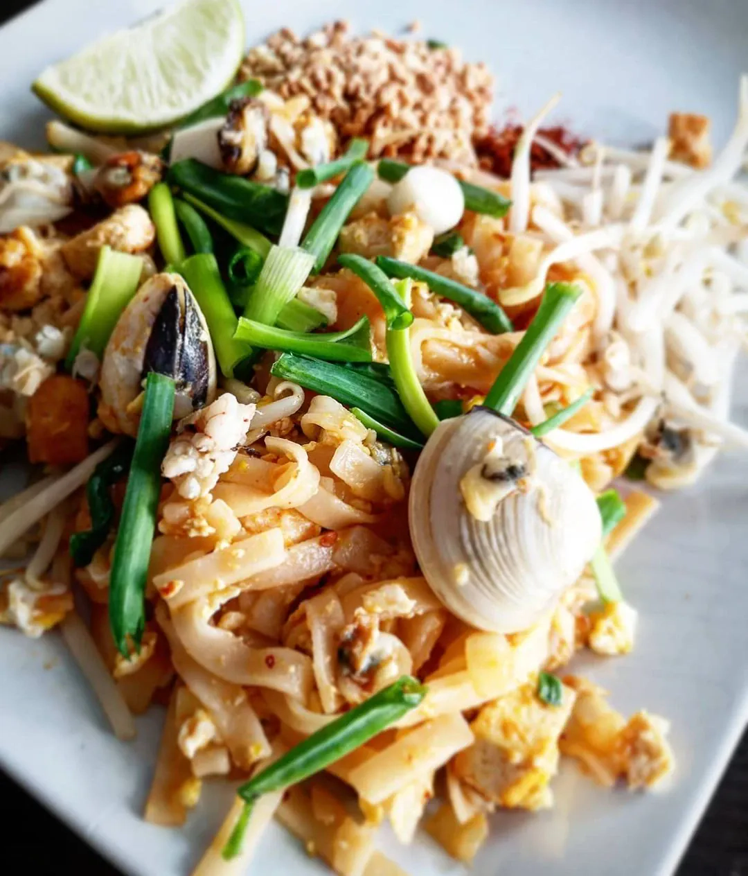 Pad thai z tofu i owocami morza z dodatkiem prażonych orzechów ziemnych oraz kiełków fasoli mung