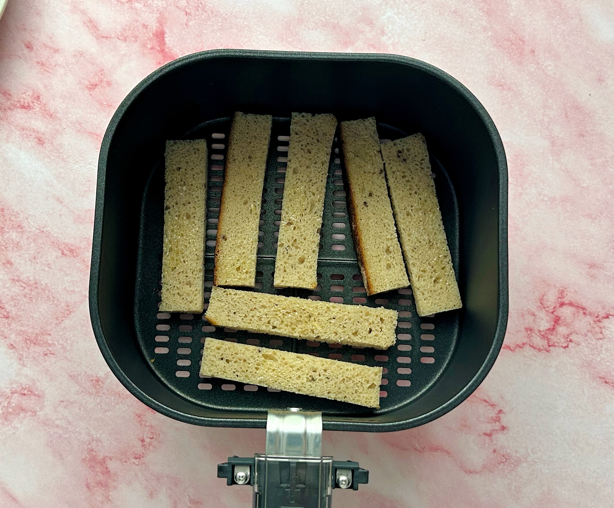 duonos juostelės išdėliotos gruzdintuvėje