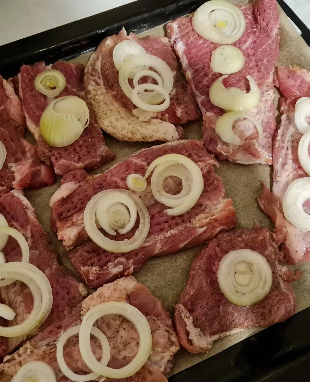 Kiaulienos sprandinės kepsniai su svogūnais, sūriu ir majonezu, kepti orkaitėje