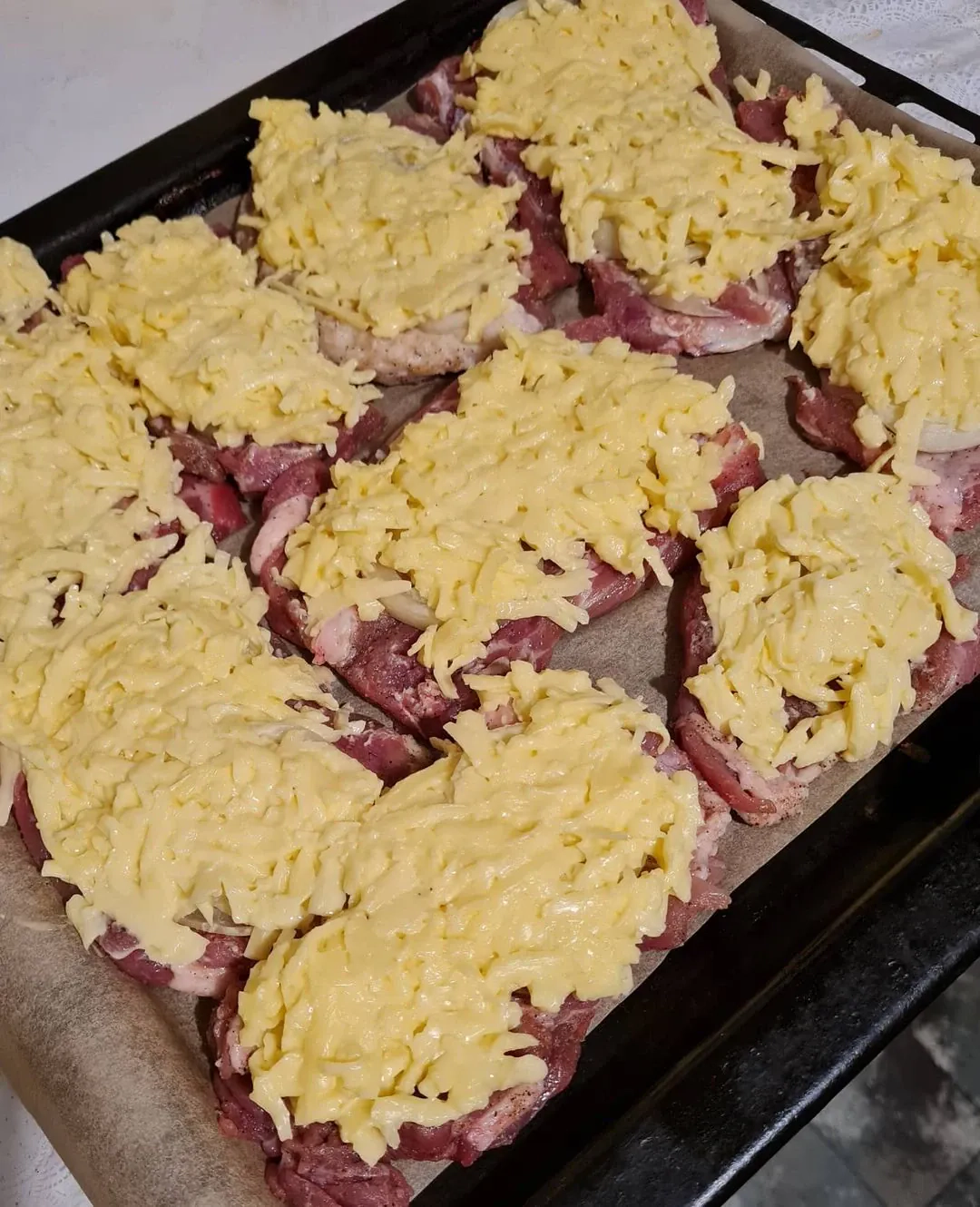 Kiaulienos sprandinės kepsniai su svogūnais, sūriu ir majonezu, kepti orkaitėje