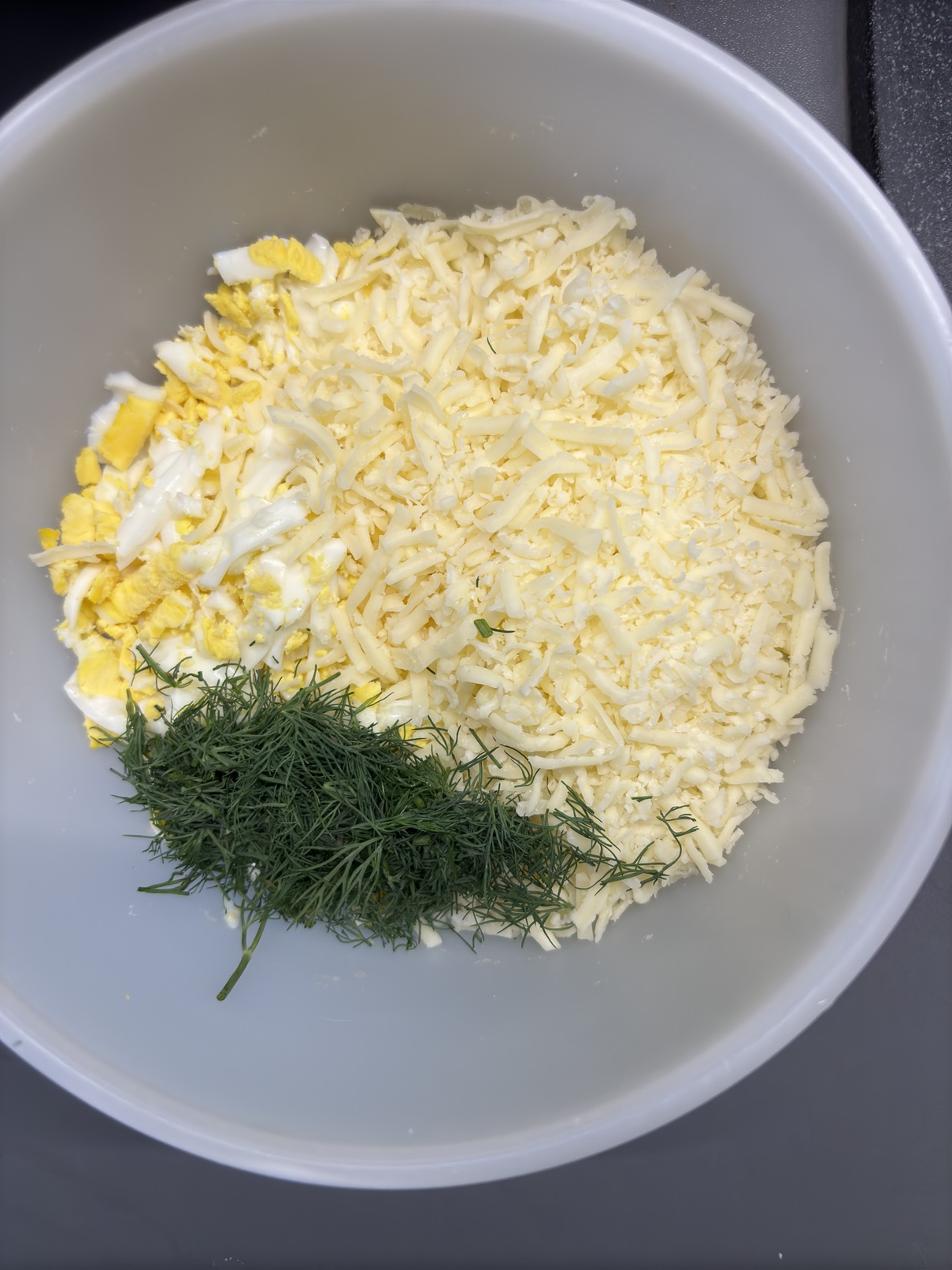 sutarkuoti kiaušiniai ir sūris su žalumynais