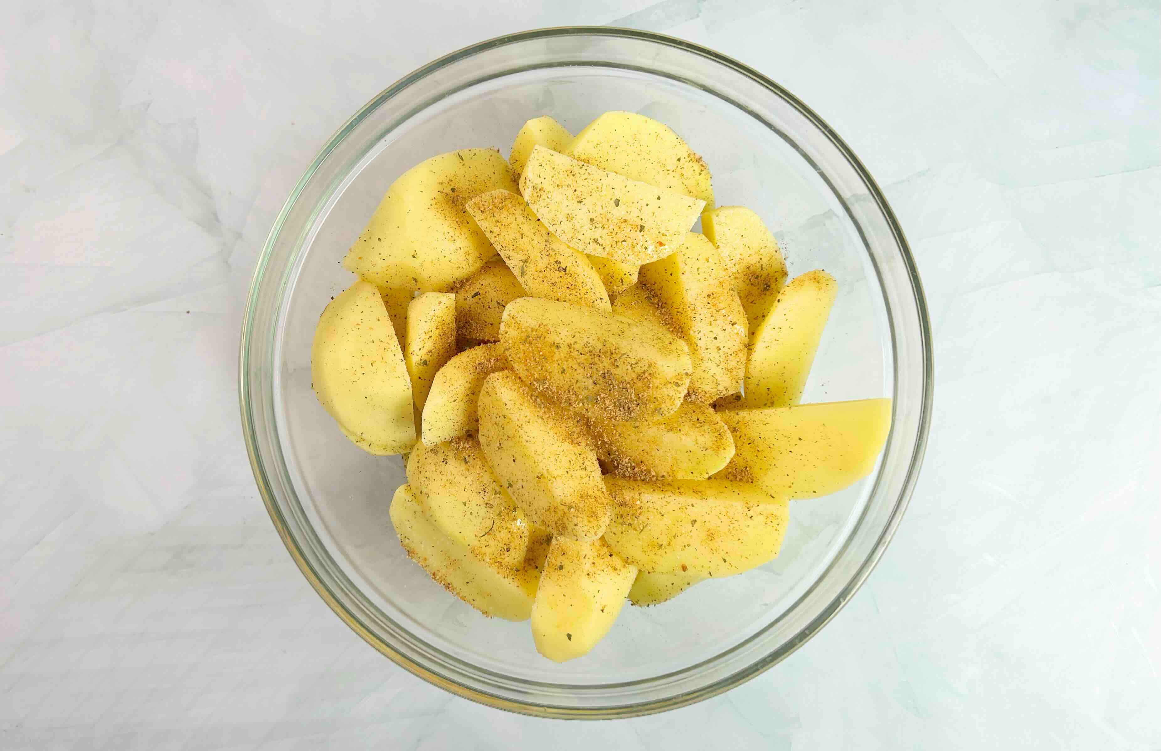 bulvės su prieskoniais dubenyje