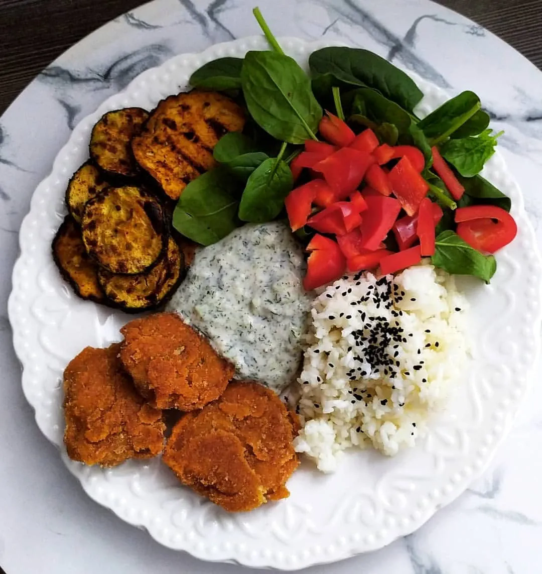 Wegańska uczta z kotletami sojowymi, grillowanymi warzywami i sosem tzatziki