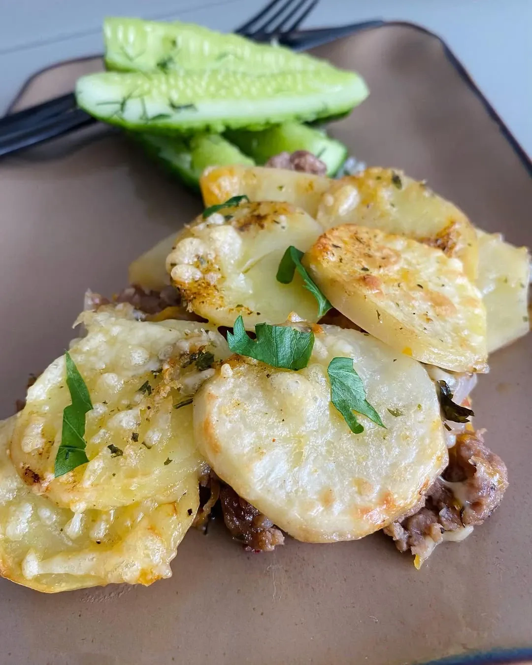 Svogūnų skonio bulvių apkepas su mėsa ir šviežiai raugintais agurkėliais