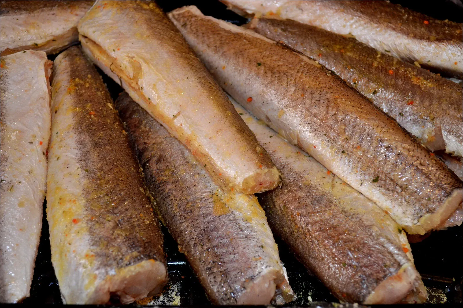 Keptas hekas heptuvėje, patiektas su keptomis bulvėmis ir grietinės-žalumynų užpilu