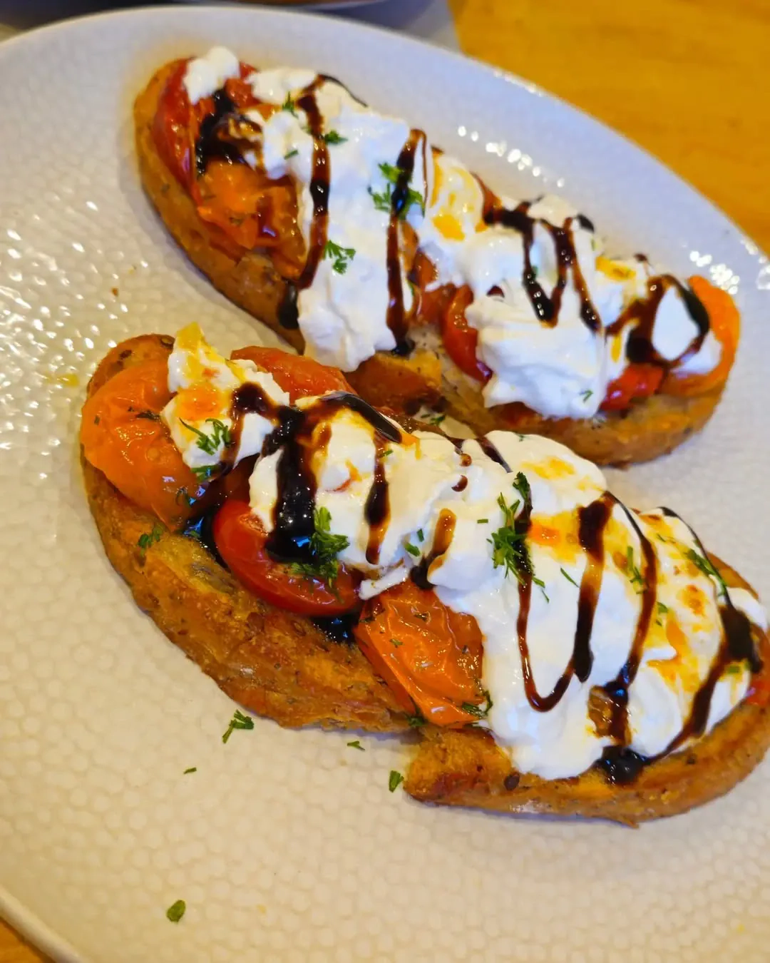 Skrudintos duonos sumuštiniai su burrata, vyšniniais pomidorais ir balzamiko padažu