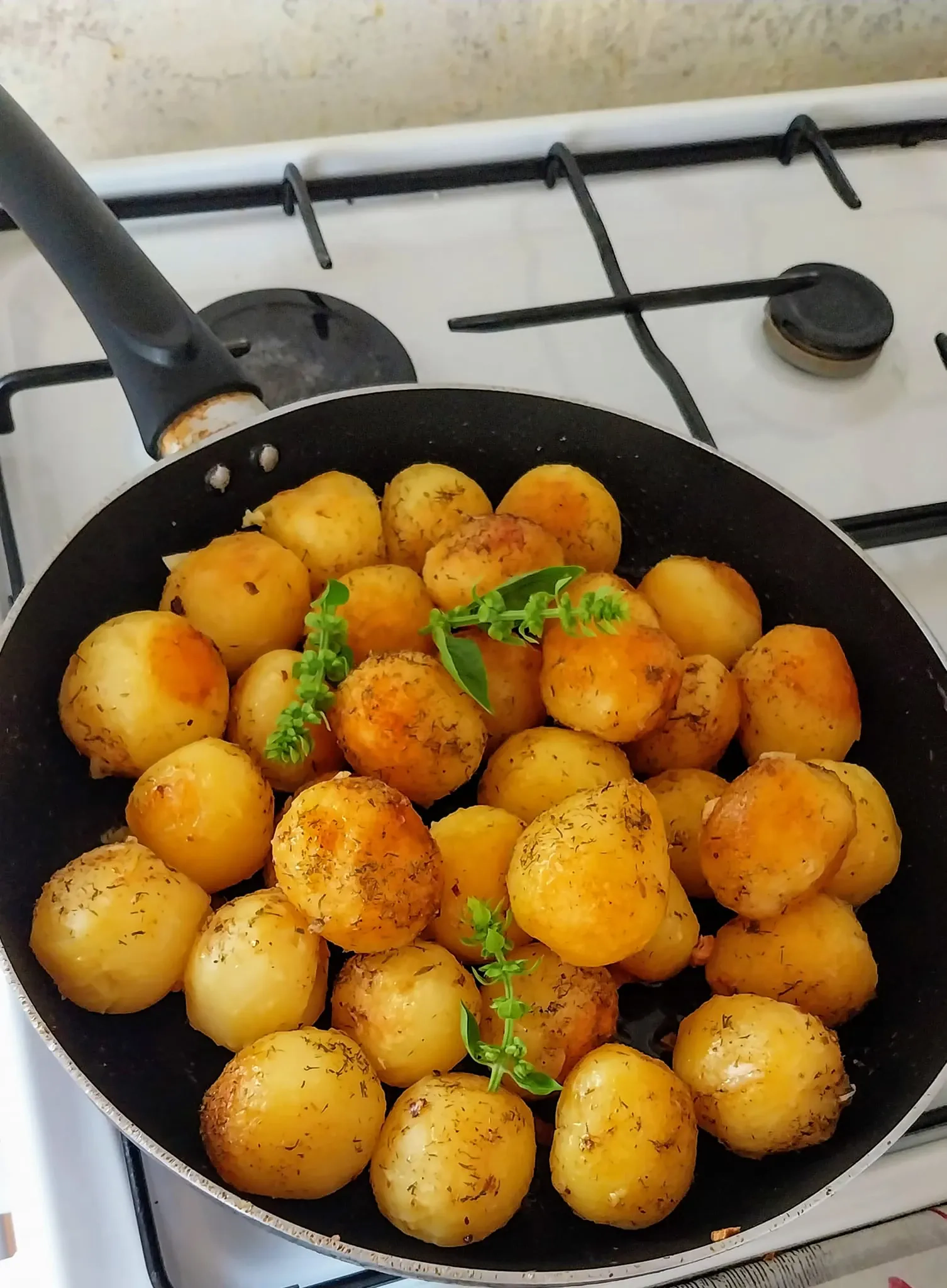 Keptuvėje keptos mažos bulvės su česnakais ir žolelėmis svieste
