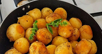 Keptuvėje keptos mažos bulvės su česnakais ir žolelėmis svieste