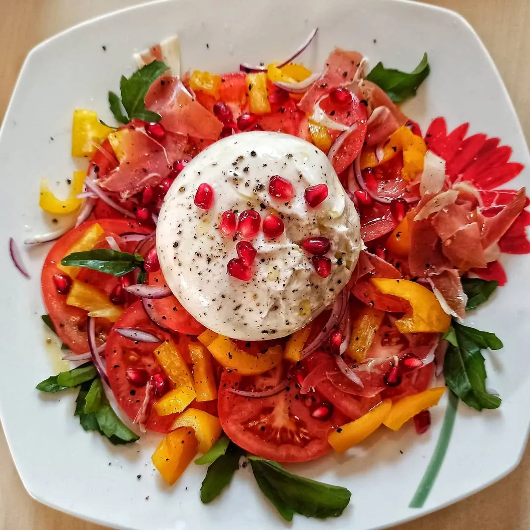 Burrata salotos su serano kumpiu ir granato sėklomis
