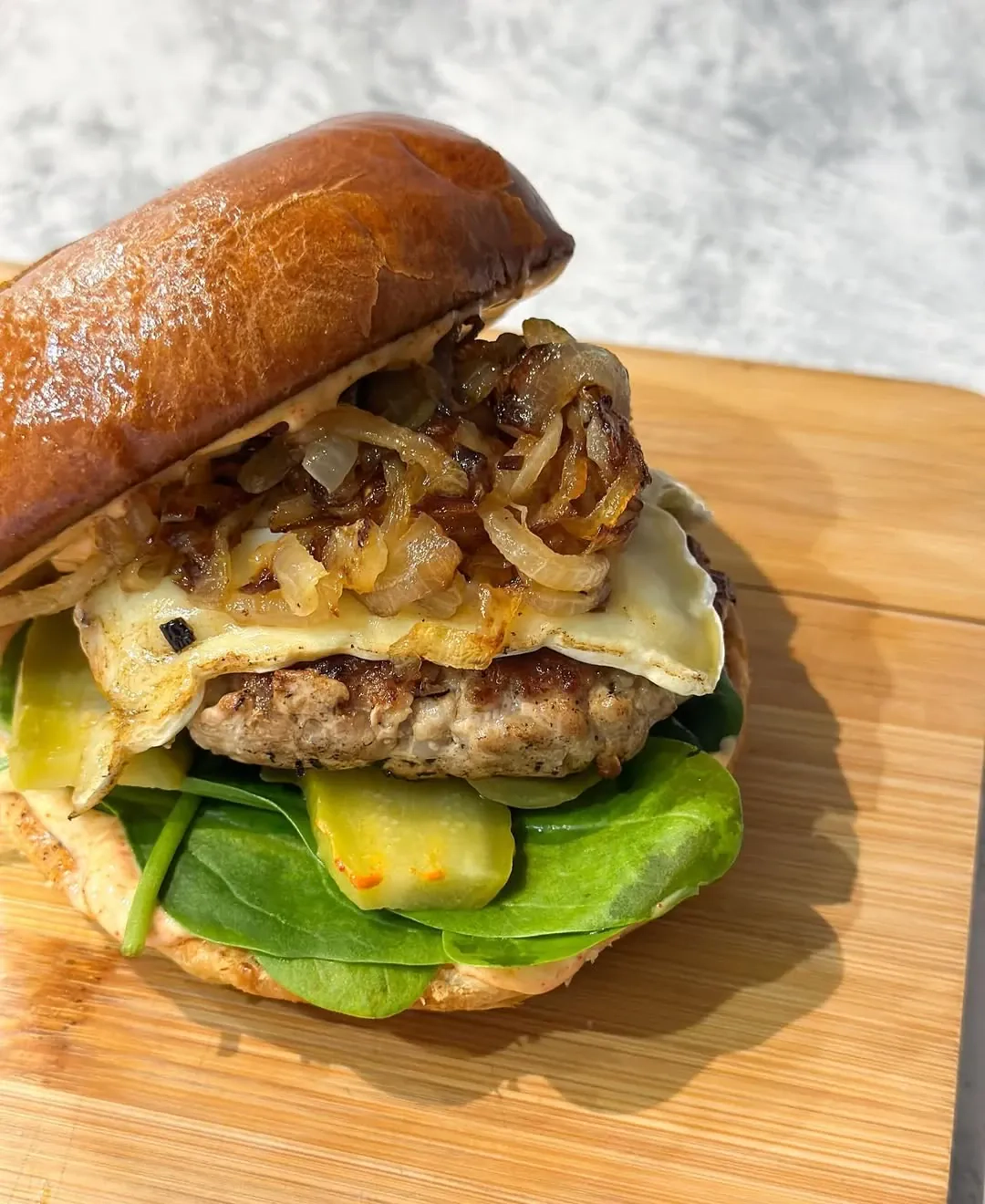 Brioche burgeris su mėsa, brie sūriu ir karamelizuotais svogūnais