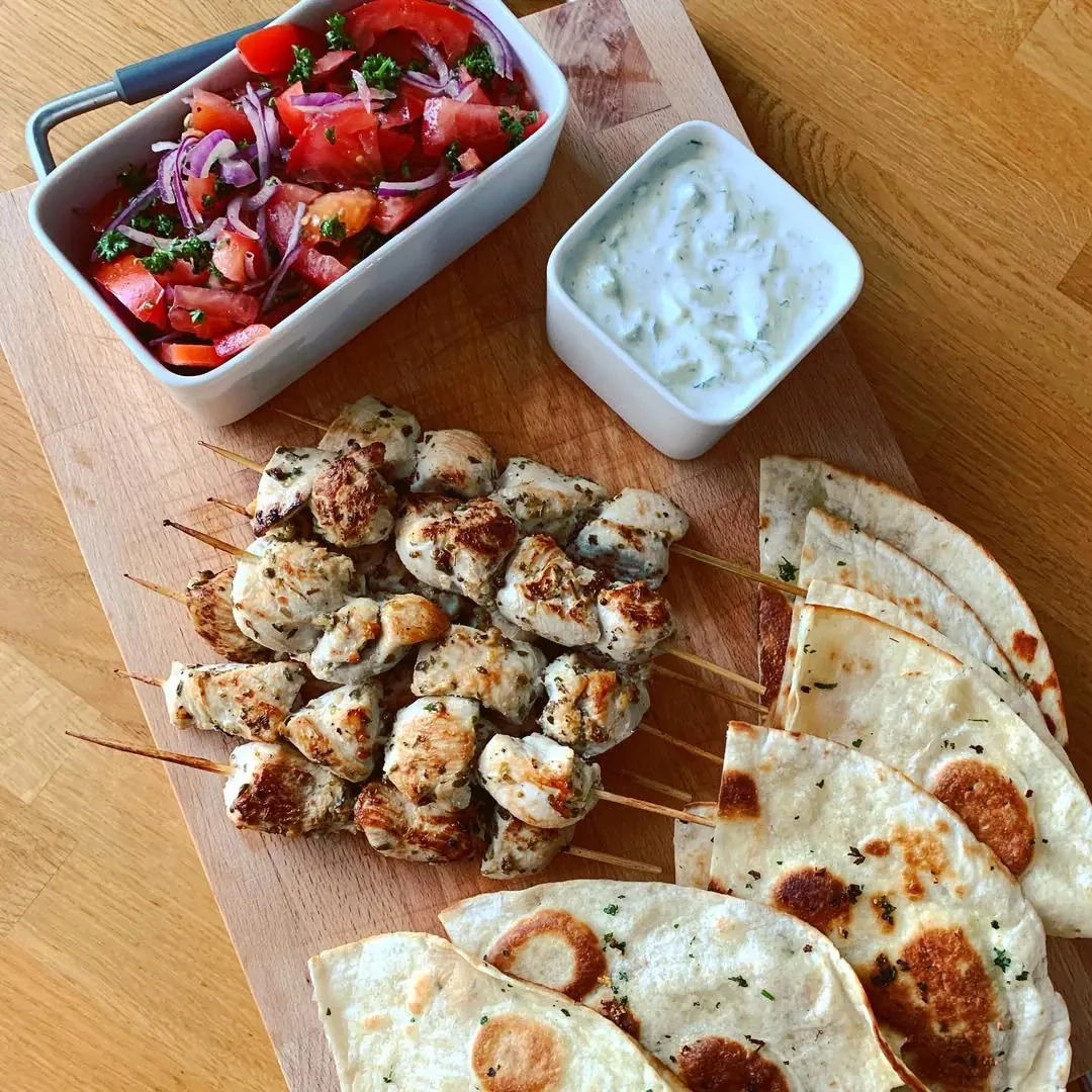 Souvlaki vištiena su česnakine tortilija, tzatziki ir pomidorais
