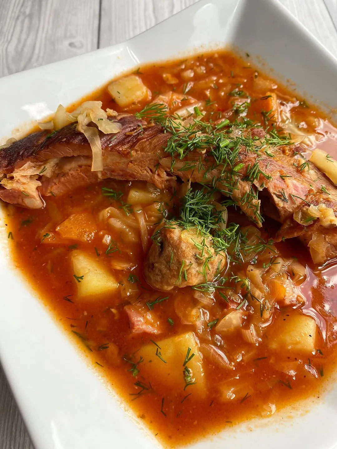 Kapuśniak z młodej kapusty na wędzonych żeberkach z mini pulpetami i boczkiem