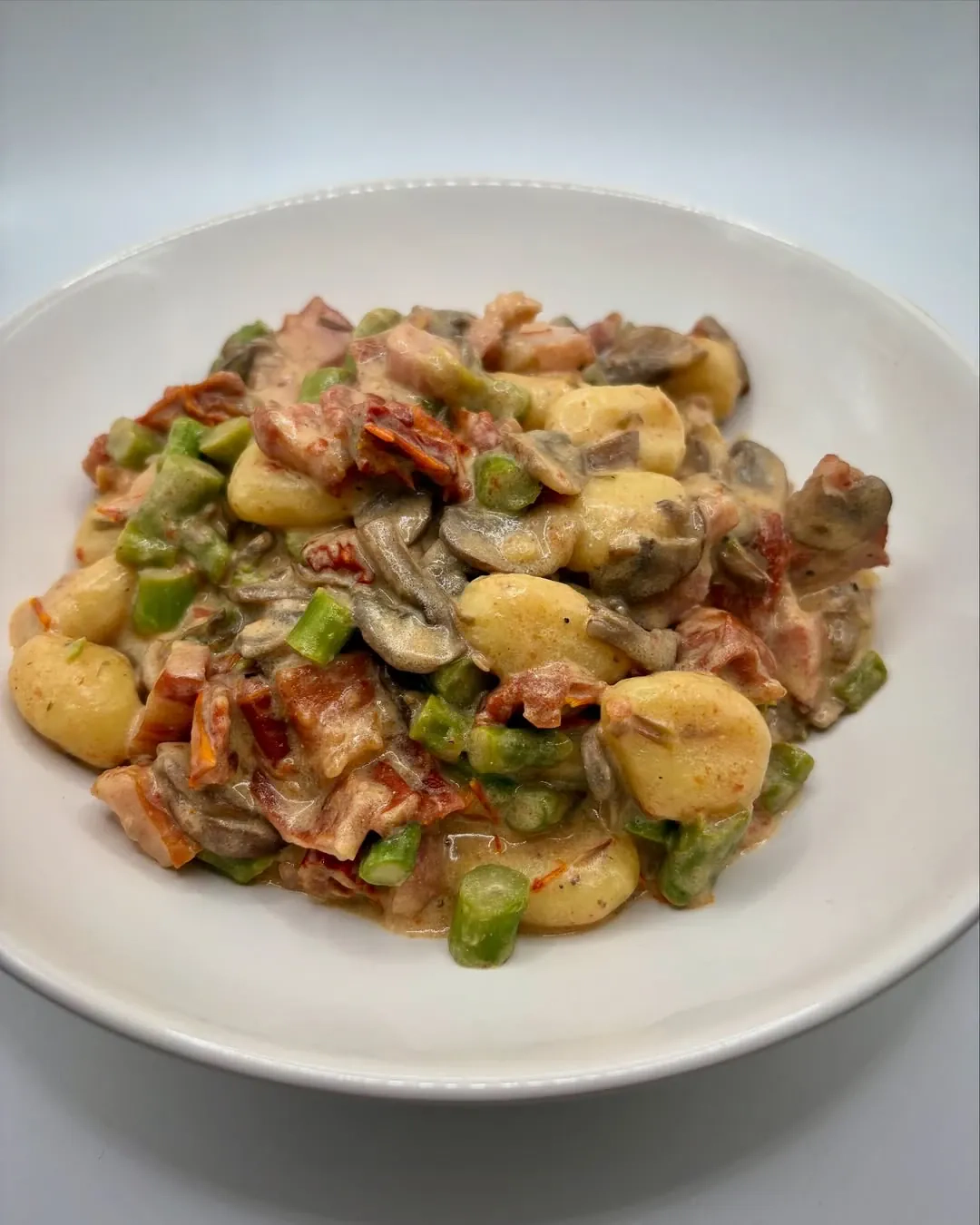 Gnocchi z boczkiem, szparagami i pieczarkami w sosie śmietanowym