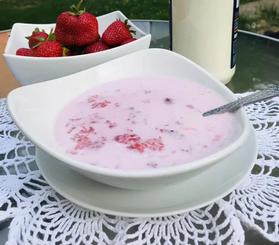 Trintos braškės su cukrumi ir šviežiu pienu vasaros desertui