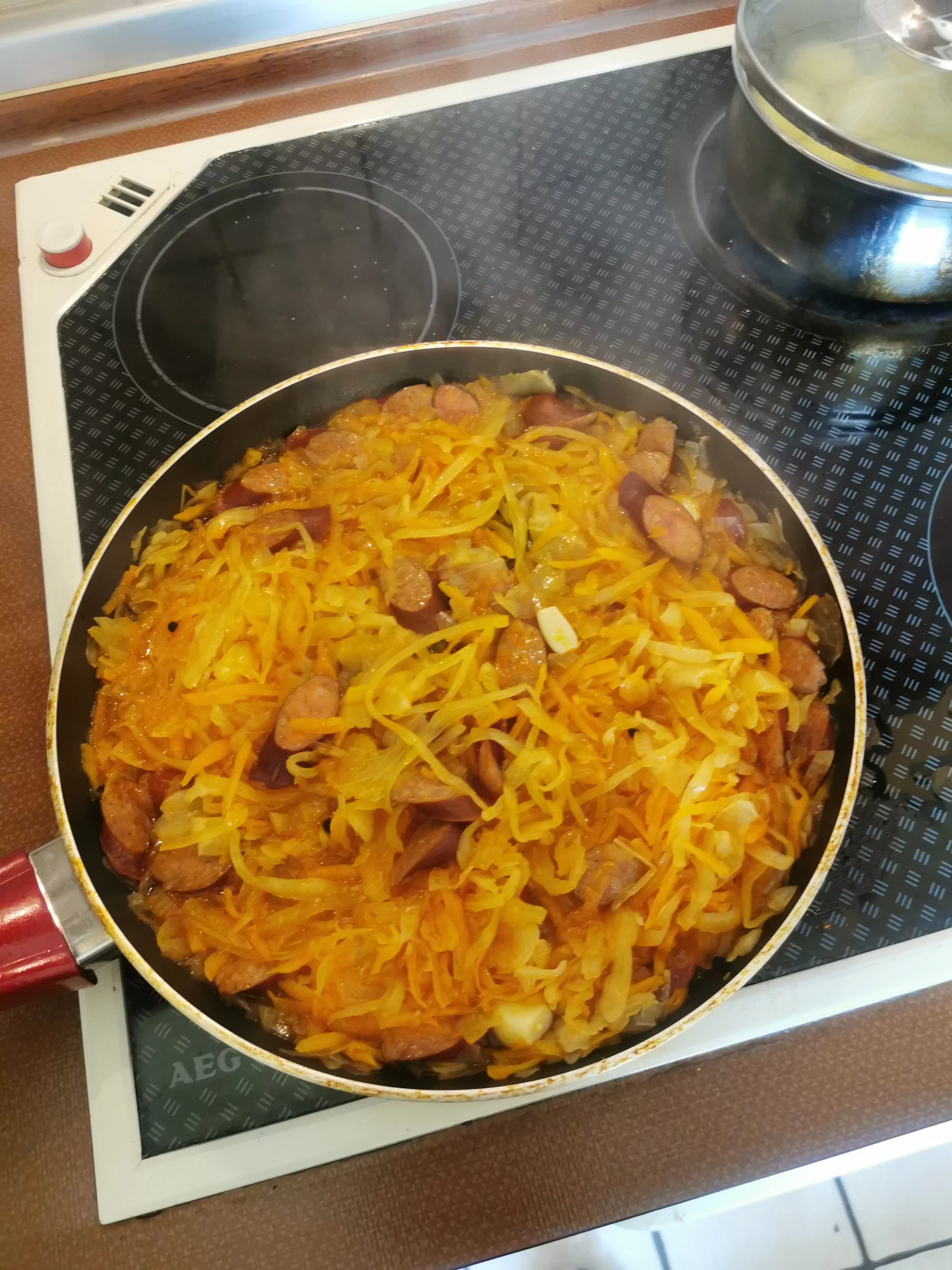 Troškinti rauginti kopūstai su dešrelėmis, morkomis ir pomidorų padažu