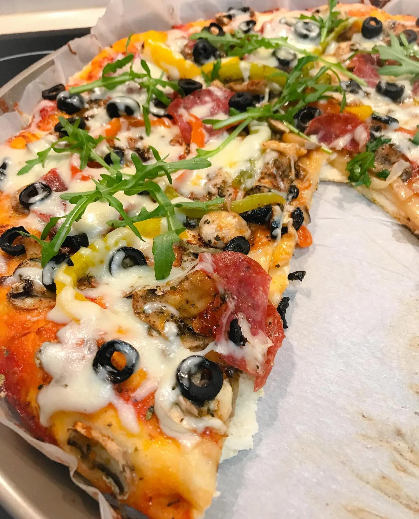 Domowa pizza z warzywami, salami i oliwkami