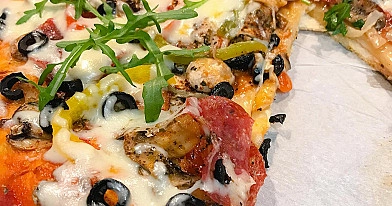 Domowa pizza z warzywami, salami i oliwkami