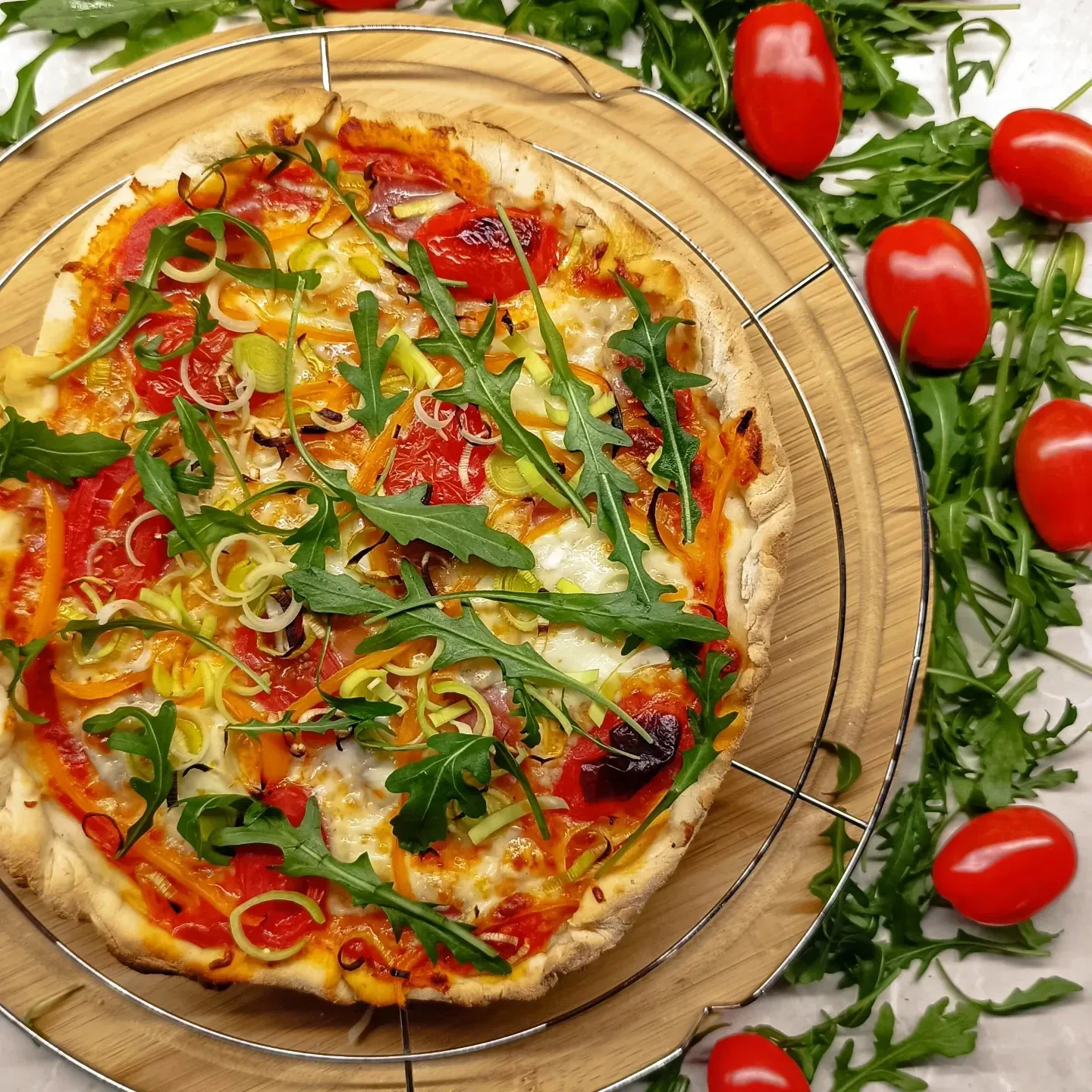 Pizza z prosciutto, rukolą i pomidorkami koktajlowymi