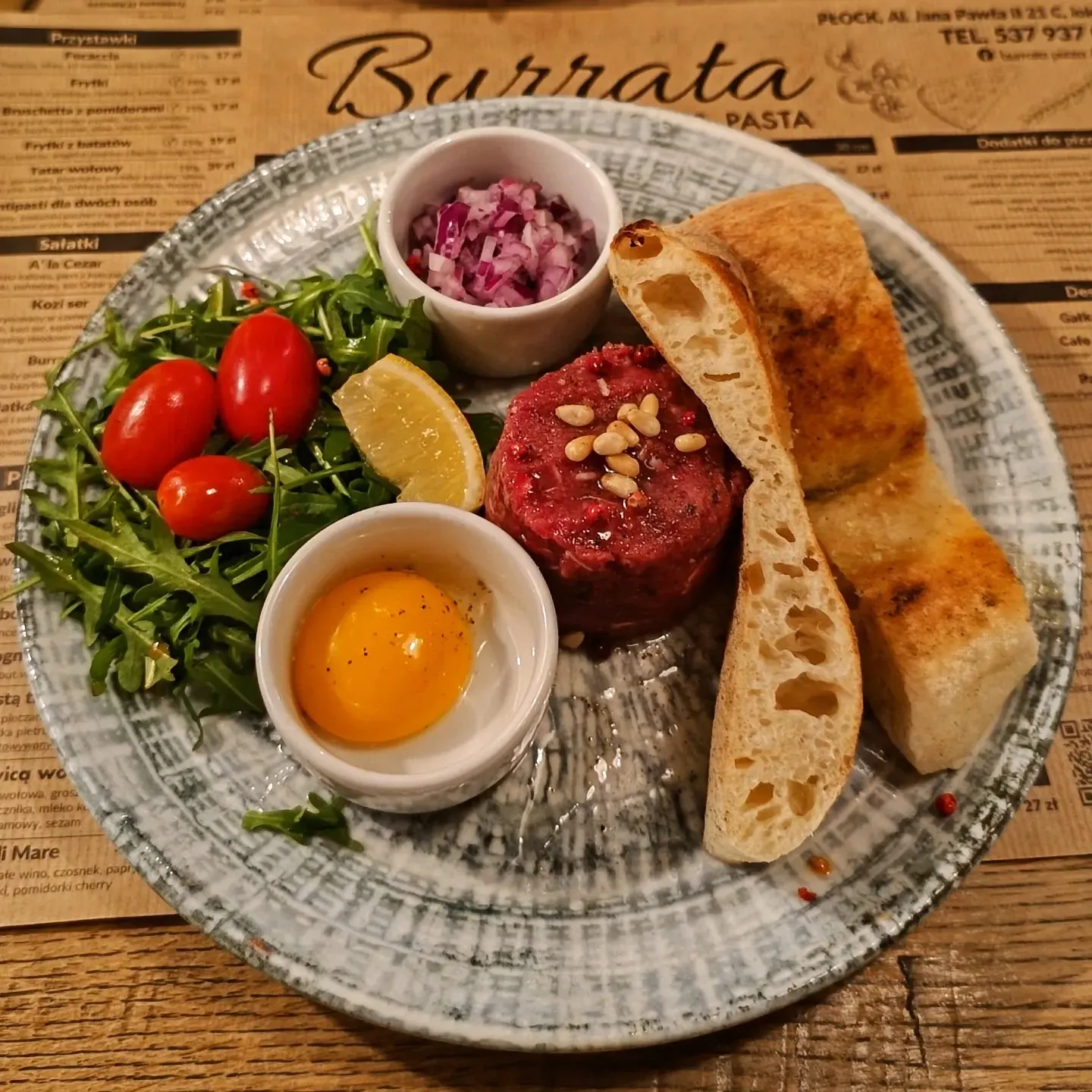 Tatarek wołowy z parmezanem, prosciutto, żółtkiem i focaccią Tatarek wołowy z parmezanem, prosciutto, żółtkiem i focaccią