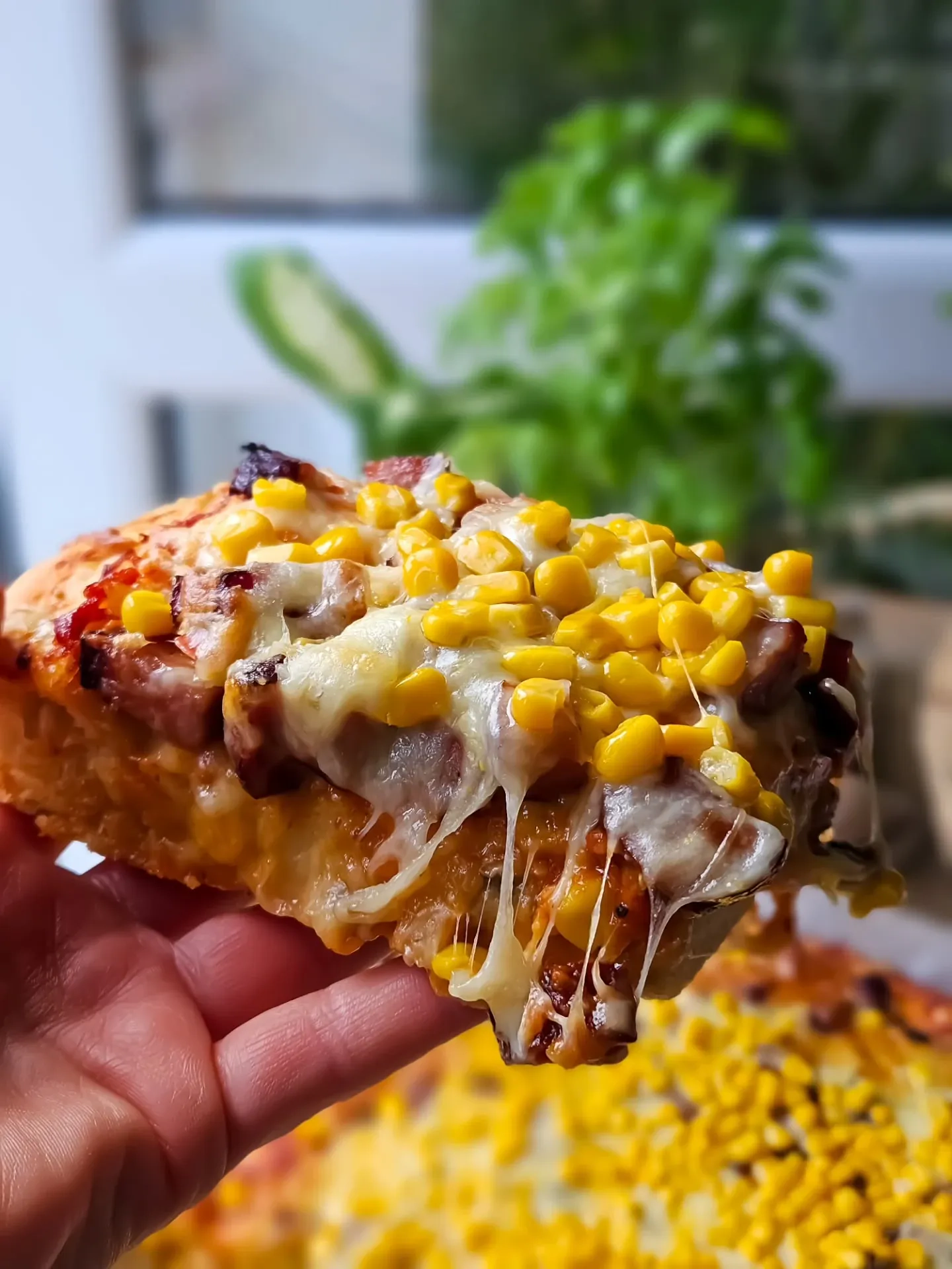 Domowa pizza na grubym cieście z kiełbasą, kukurydzą i serem