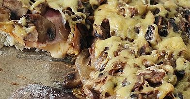 Domowa pizza na grubym cieście z szynką, pieczarkami i serem