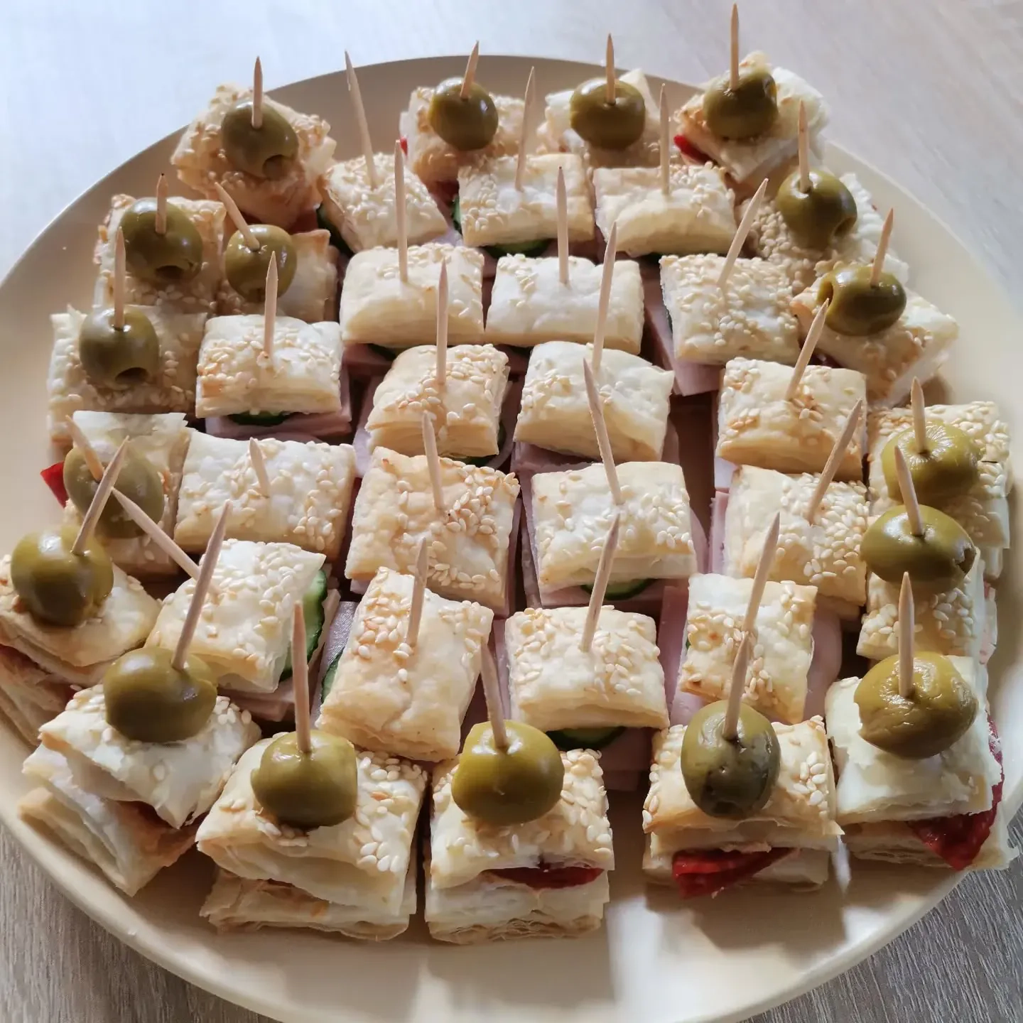 Sluoksniuoti tešlos užkandžiai su sūriu, kumpiu ir alyvuogėmis