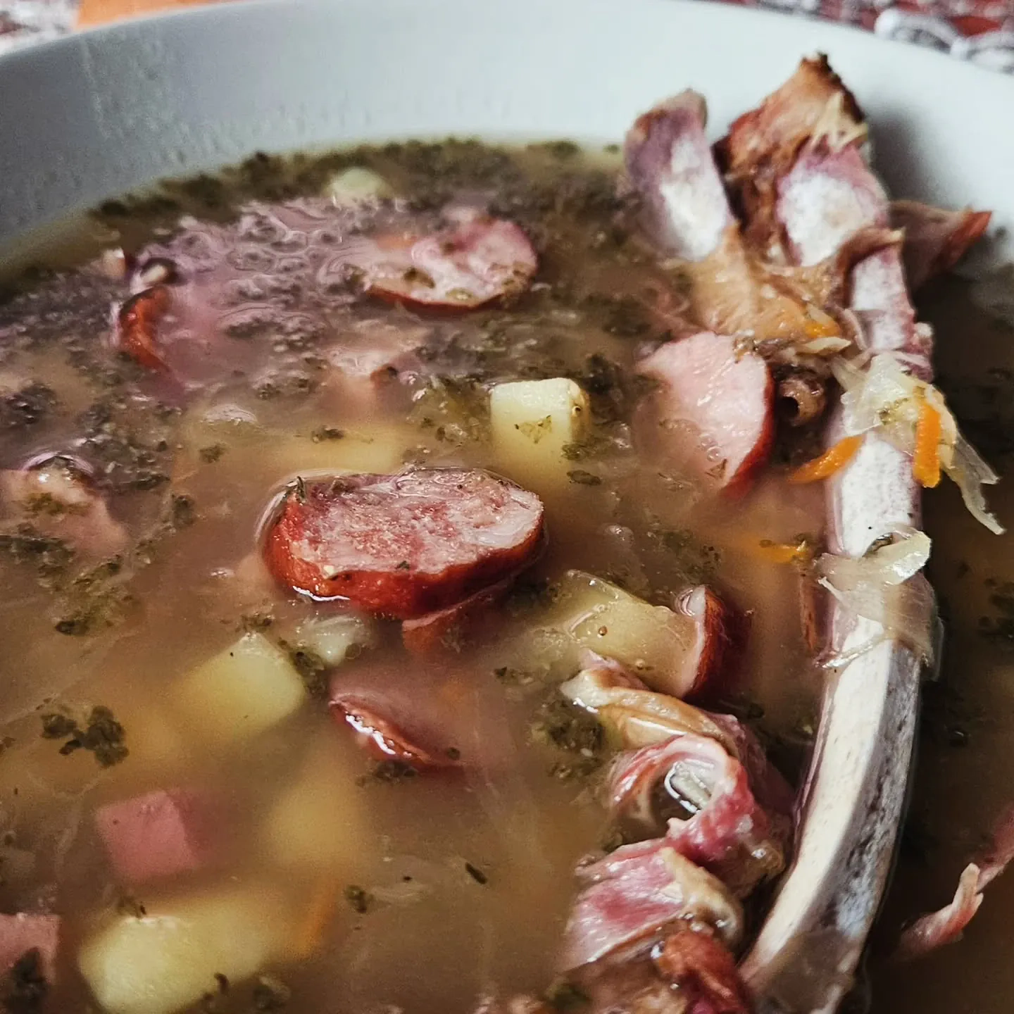 Kapuśniak z kiszonej kapusty na wędzonych żeberkach jagnięcych z kiełbasą i ziemniakami