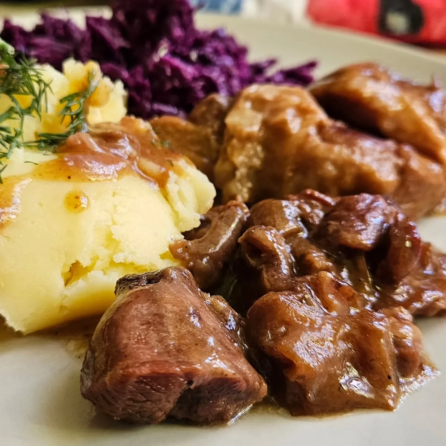 Duszone mięso wołowo-wieprzowe w sosie własnym z tłuczonymi ziemniakami i surówką z czerwonej kapusty