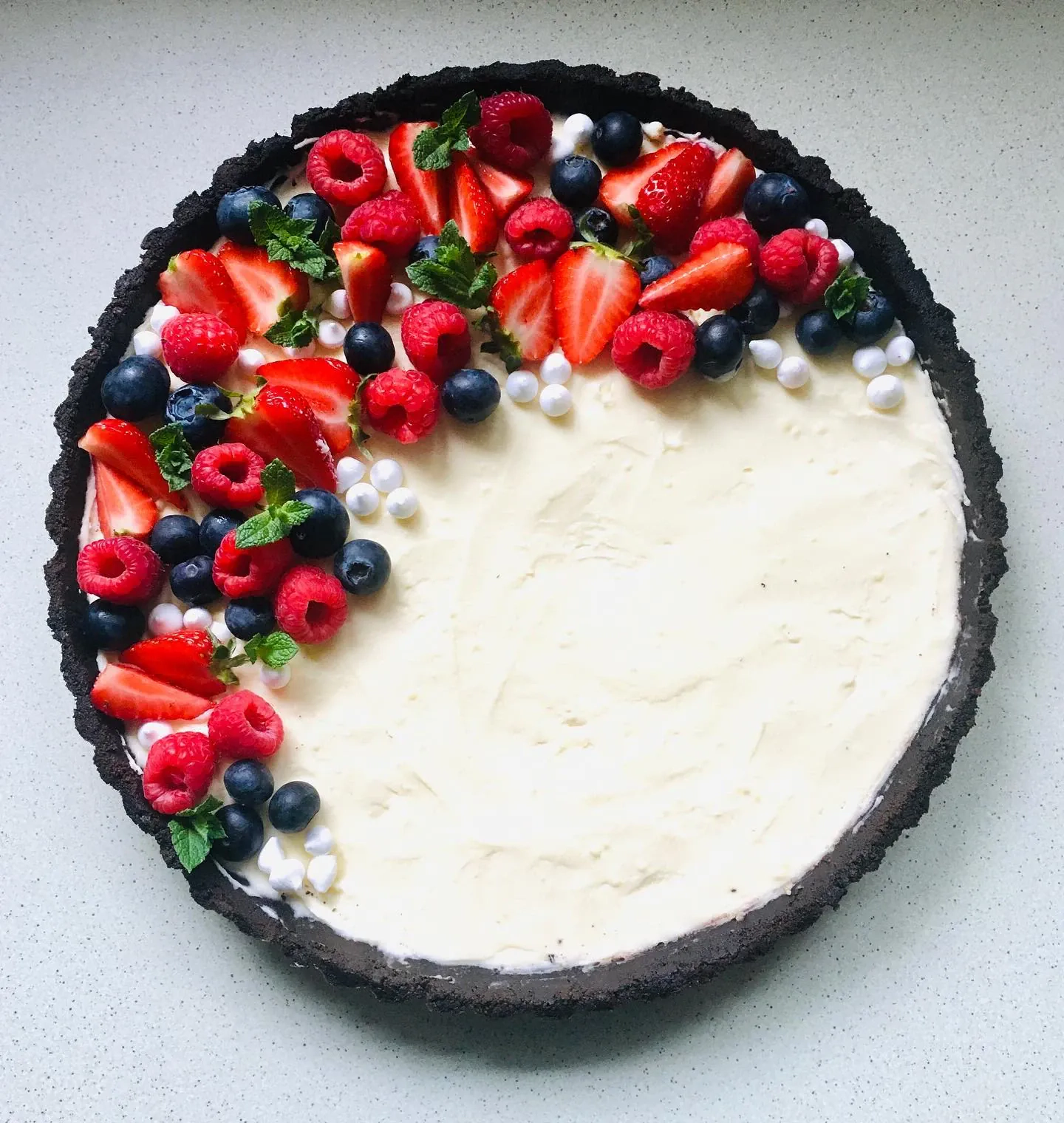 Tarta z kremem waniliowym i owocami na spodzie z ciasteczek Oreo