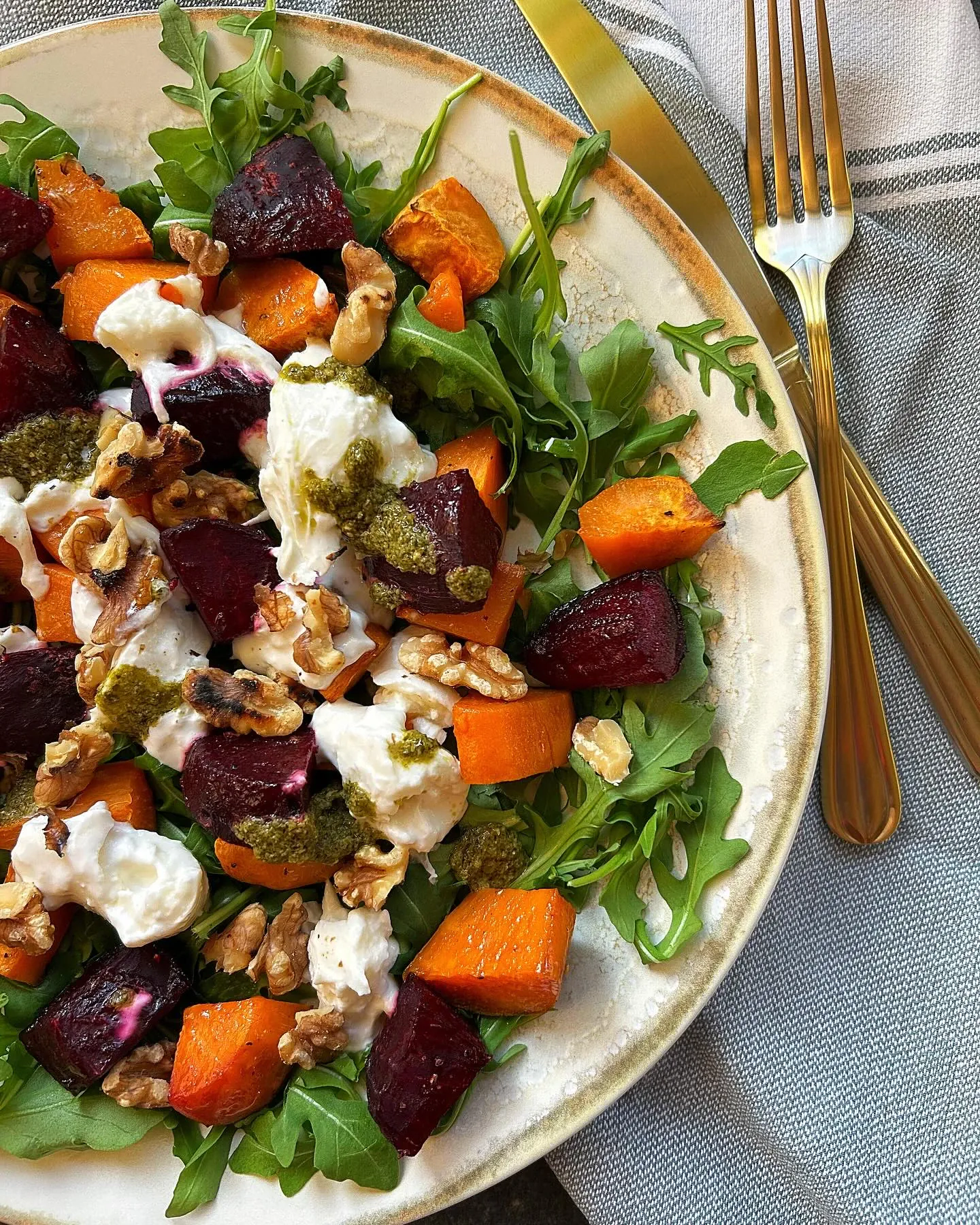 Pieczone bataty i buraczki z rukolą, burratą, orzechami włoskimi i zielonym pesto