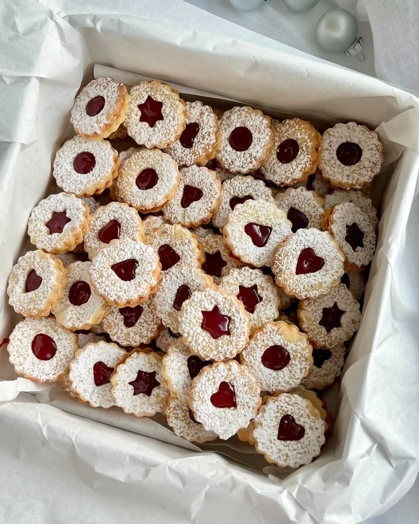 Kruche ciasteczka migdałowe z dżemem malinowym i cukrem pudrem