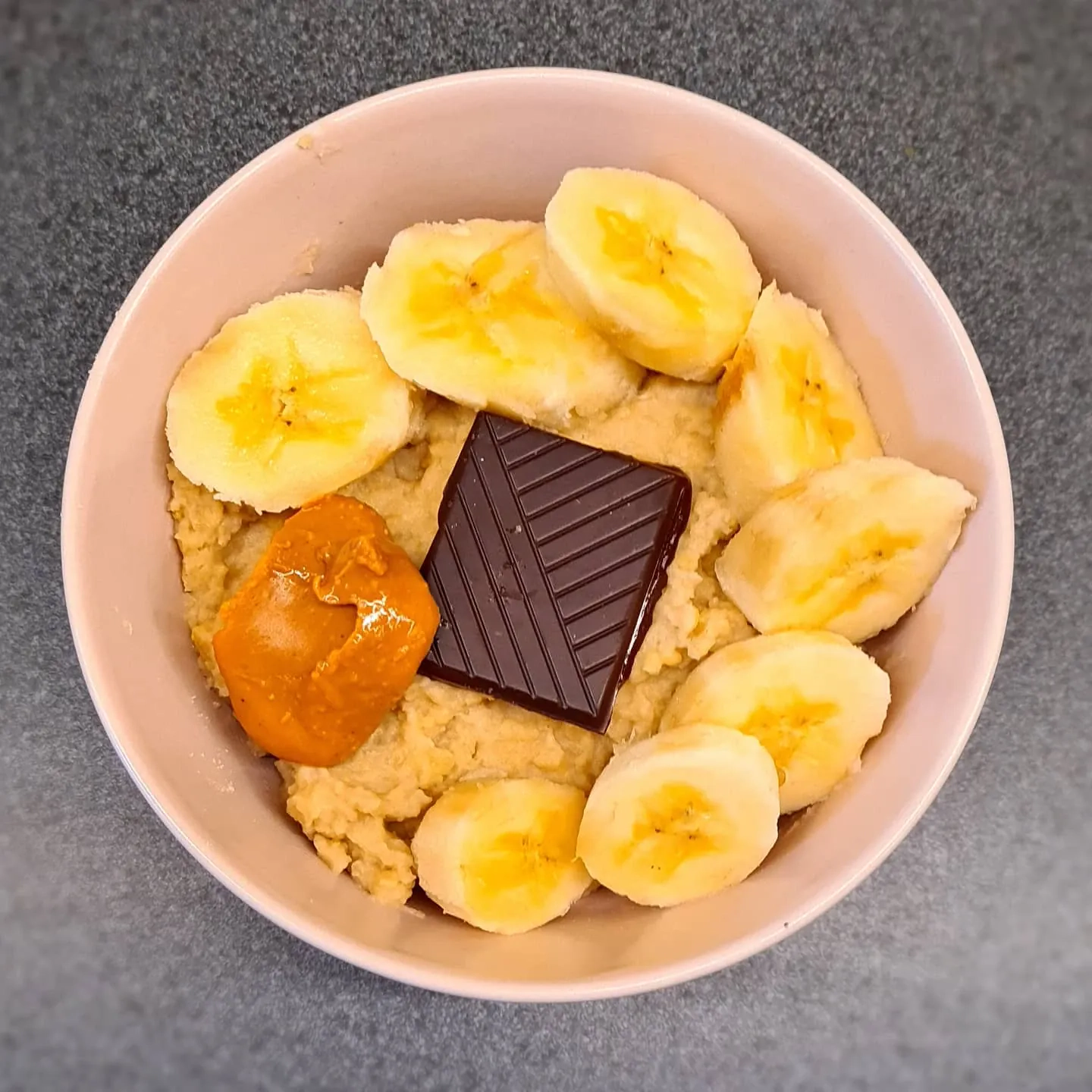 Kukurūzas polenta putra ar lazdu riekstu pienu, banāniem, melno šokolādi un zemesriekstu sviestu