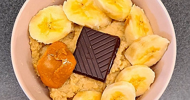 Kukurūzas polenta putra ar lazdu riekstu pienu, banāniem, melno šokolādi un zemesriekstu sviestu