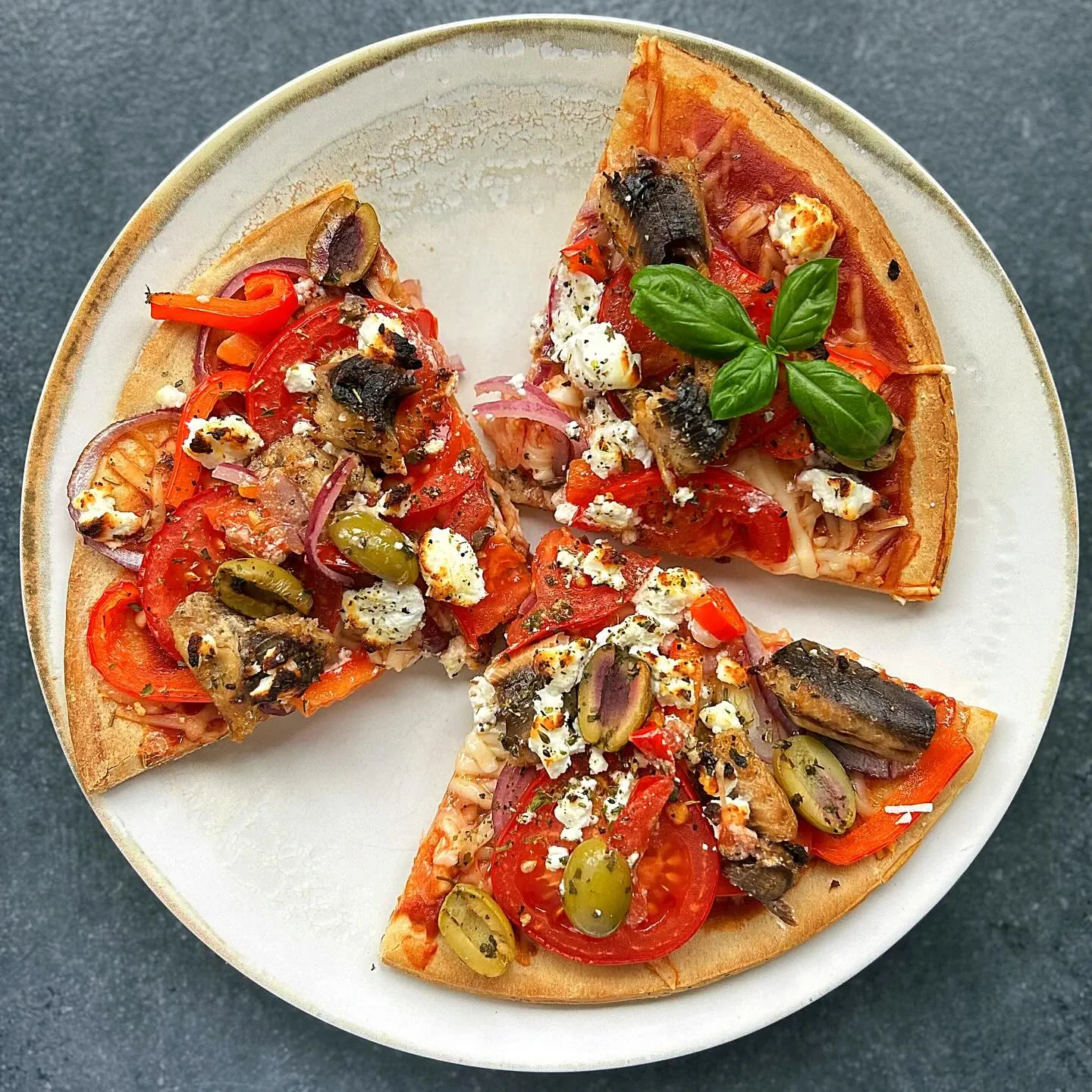 Pizza z sardynkami, oliwkami i kozim serem na cienkim cieście