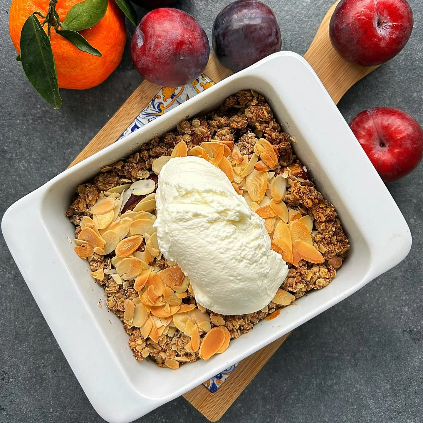 Kruszonka (crumble) ze śliwkami i migdałami, podawana z jogurtem