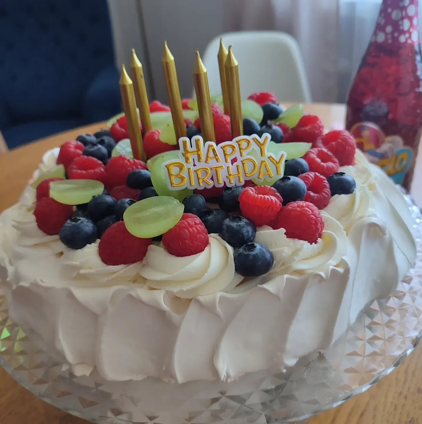 Tort bezowy urodzinowy z bitą śmietaną i owocami leśnymi