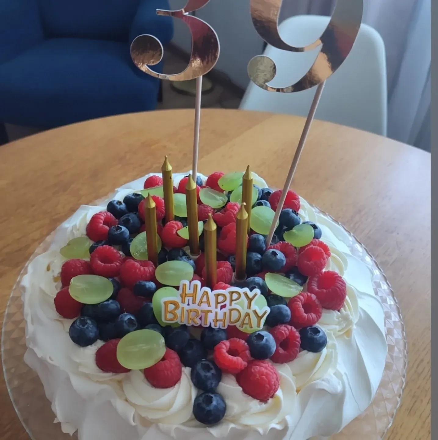 Tort bezowy urodzinowy z bitą śmietaną i owocami leśnymi